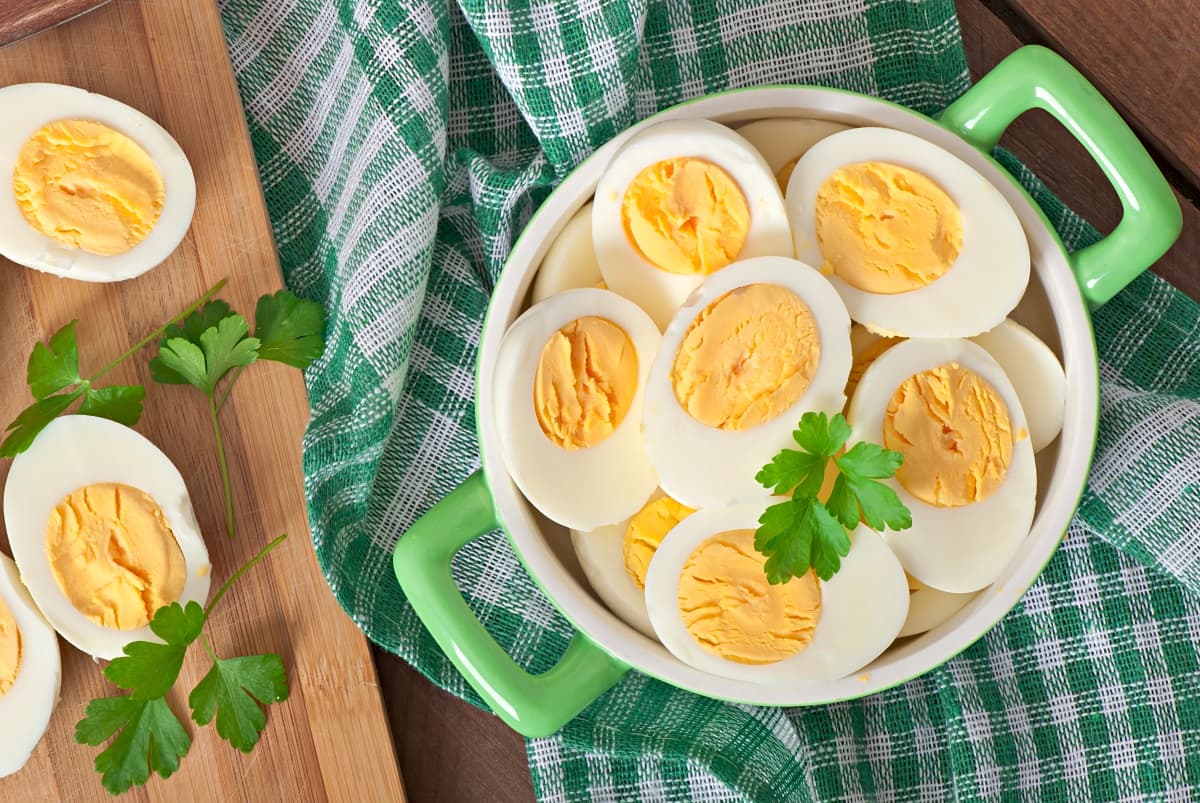 Boiled eggs in a bowl decorated with fresh parsley leaves