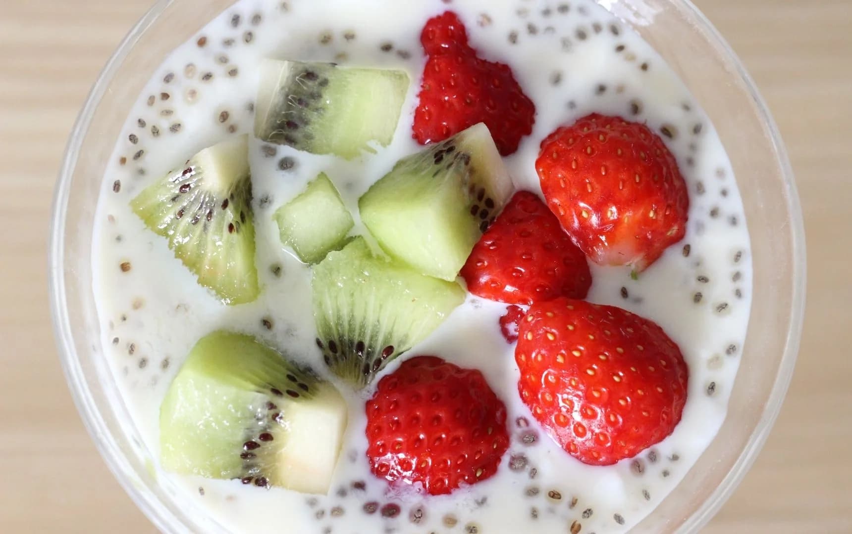 Greek yogurt with chia seeds topped with kiwi slices and fresh strawberries