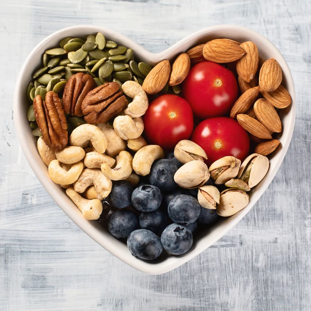 top view lots of nuts in the heart shape white bowl