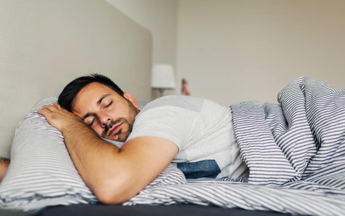 a man sleeping on a bed with a pillow on his head