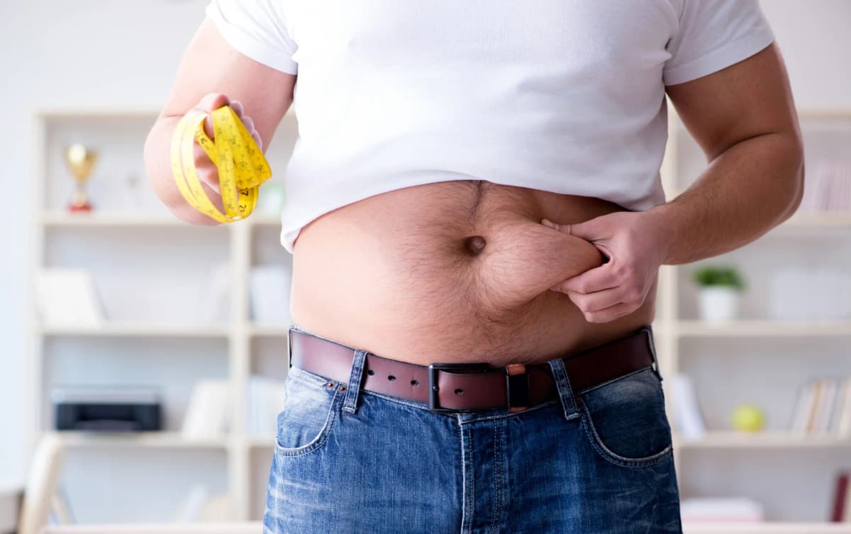 a man checking his belly fat with hands