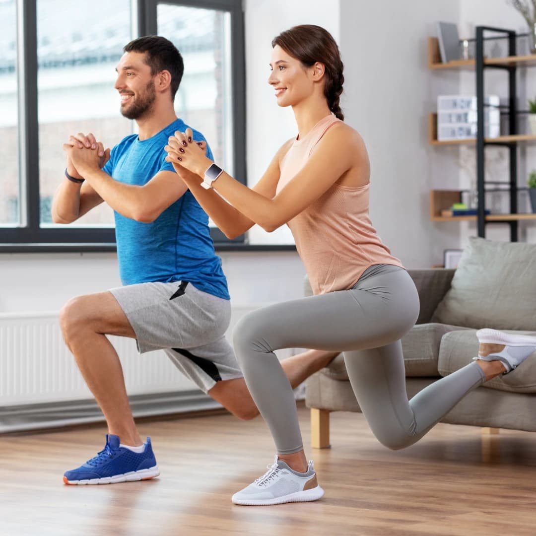 Man and woman doing lunges workout at home for strength and fitness