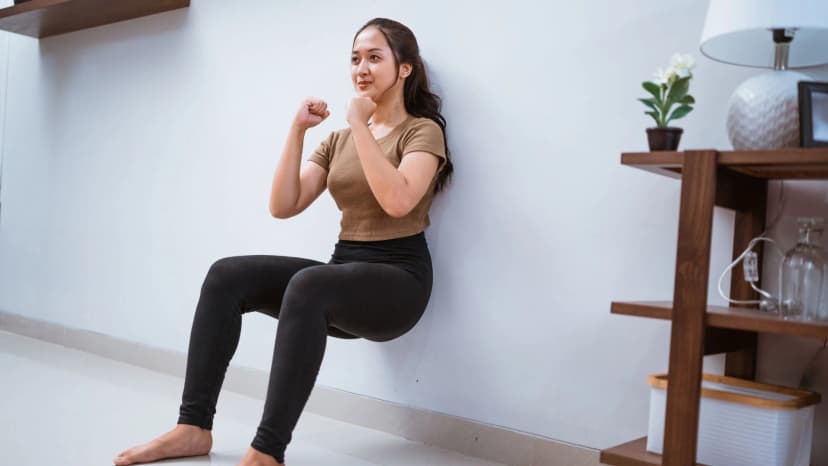 Female doing wall sit exercise during home workout
